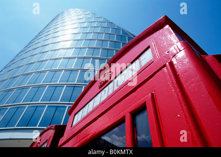 Un tradizionale telefono rosso scatola con vetro frontale City building in background Foto Stock