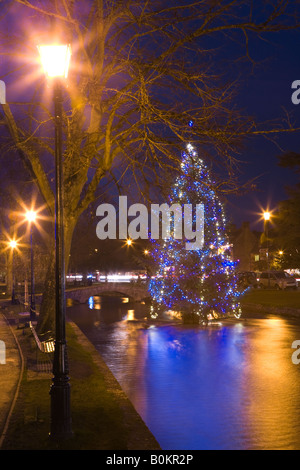 Un albero di Natale nel centro del Fiume Windrush nel villaggio Costwold di Bourton sull'acqua, Gloucestershire Foto Stock