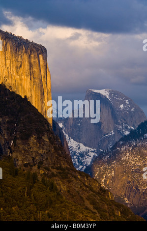 La luce del tramonto su El Capitan e nuvole temporalesche oltre mezza cupola e il Parco Nazionale di Yosemite Valley Yosemite National Park in California Foto Stock