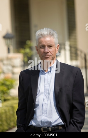 Agente immobiliare maschio in piedi al di fuori di fronte a casa in vendita Foto Stock