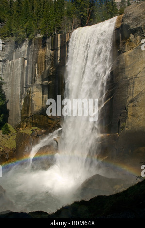 Rainbow alla base della caduta primaverile cascate Yosemite National Park in California Foto Stock
