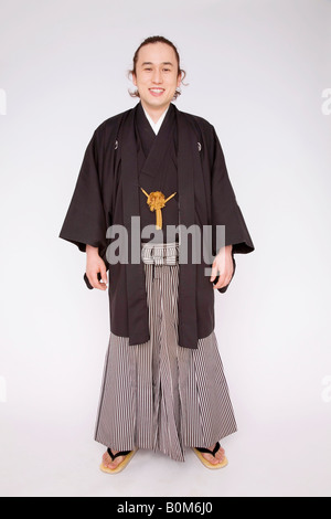 Uomo giapponese di indossare il kimono seduto sul pavimento nella casa  tradizionale giapponese, utilizzando il telefono cellulare Foto stock -  Alamy