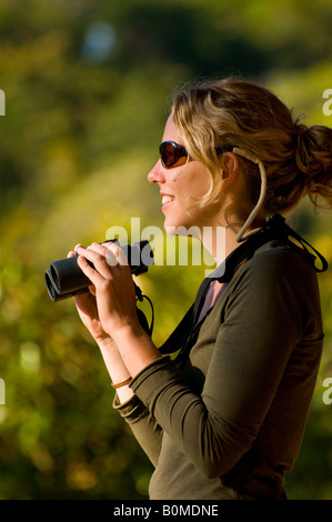 COSTA RICA Donna bird watching con il binocolo nella foresta pluviale Foto Stock