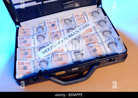 Una valigia piena di soldi con la parola le bollette di casa fondo attraverso di esso Foto Stock