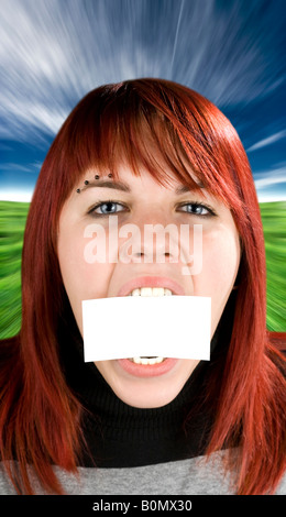 Redhead girl aggressivamente mordere o mangiare un bigliettino vuoto concetto esprime la nutrizione o disturbo alimentare problemi Foto Stock