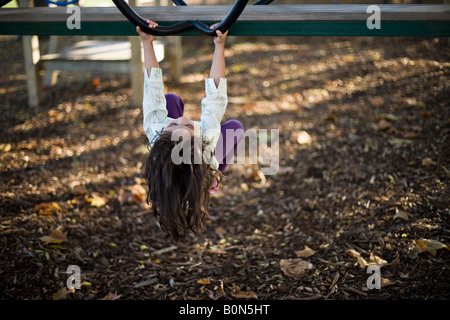 La ragazza è appeso a testa in giù nel parco giochi avventura Foto Stock