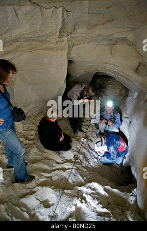 Persone per misurare la lunghezza mentre esplorate la grotta presso Vaidavas hillfort in Gauja Parco Nazionale della Lettonia Foto Stock