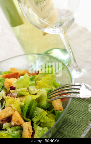 La Caesar salad è servito in una ciotola di vetro e vino bianco Foto Stock