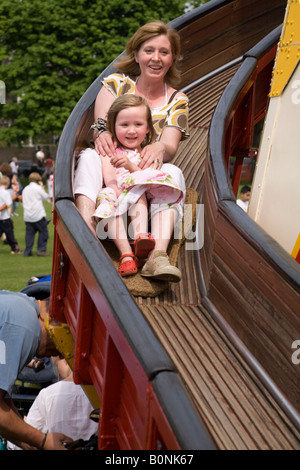 Madre e figlia sul Helter Skelter slitta a Richmond Upon Thames Fiera di Maggio. Richmond upon Thames. Surrey. Regno Unito. Foto Stock