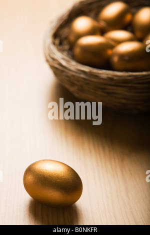 Nido di uova d'oro con singolo uovo in primo piano Foto Stock