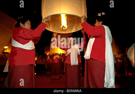 Tailandese donne festeggiare Loy Krathong rilasciando carta tradizionali mongolfiera kom 'fai' nel cielo notturno, Mae Jo, Chiang Mai, Thailandia Foto Stock