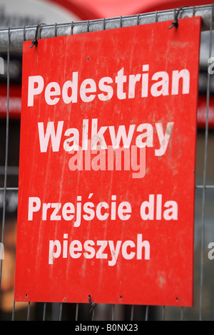 Bilingue passerella pedonale sign in inglese e polacco su un sito in costruzione a Belfast City Centre Foto Stock