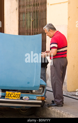 Uomo cubano è la riparazione di una vecchia vettura russa. Santiago de Cuba. Cuba. Foto Stock