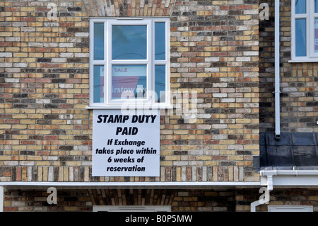 Parte del nuovo blocco di appartamenti con unità di vendita e di avviso indicante un risparmio sui costi di bollo se il completamento rapido Foto Stock