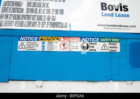 Vari dispositivi di sicurezza segni di promemoria in un cantiere edile a New York Foto Stock