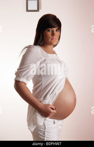 36 settimana incinta Donna adolescente mostrando il suo esposto lo stomaco . Foto Stock