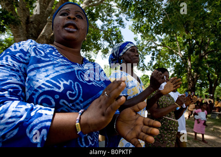 Le donne cantando e battendo le mani durante una cerimonia nel villaggio di Agbenoxoe Foto Stock