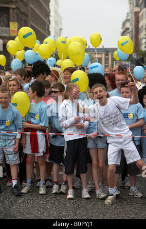 La folla di bambini concorrenti con palloncini linea fino alla linea di partenza della maratona di Belfast fun run 2008 Belfast City Centre n Foto Stock