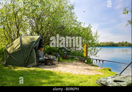 Carpa pescatore sulle rive del ponte Neigh Country Park, Cotswold Water Park, Gloucestershire, England, Regno Unito Foto Stock