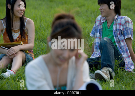 Tre giovani relax nel parco Foto Stock
