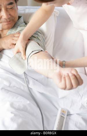 L'infermiera facendo pressione del sangue del paziente Foto Stock