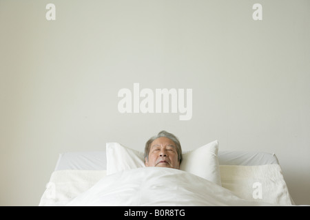 Senior uomo dorme nel letto Foto Stock
