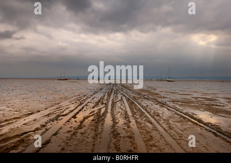 Barche in distanza al di sotto del cielo tempestoso su West Kirby tidal velme Foto Stock