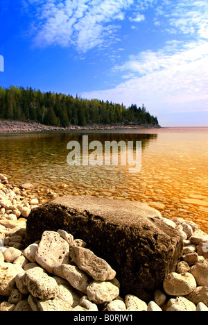 Bellissima vista su una spiaggia rocciosa con acqua chiara e riflessi dorati Georgian Bay in Canada Foto Stock