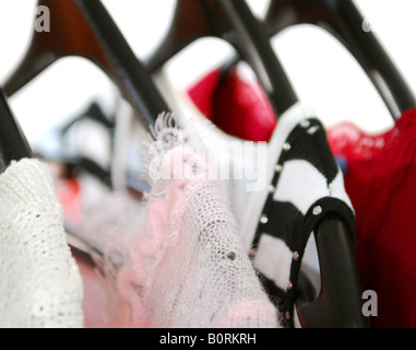 Le donne s su capi di abbigliamento una cremagliera su nero appendiabiti Foto Stock