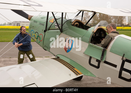 CASA (Bucker) 1-131E Jungmann G-BJAL mostra pilota nel pozzetto con la seconda persona swinging ventola per avviare il motore Foto Stock