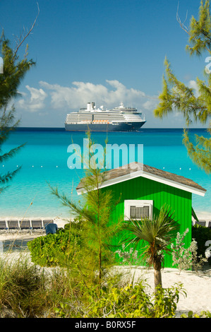 Un colorato verde beach cabana con la Holland America nave da crociera Westerdam ancorate al largo di Half Moon Cay Bahamas Foto Stock