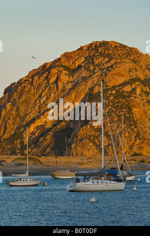 Barche a vela ancorata nella parte anteriore del Morro Rock a sunrise Morro Bay California Foto Stock