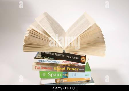Pila di libri in brossura. Libro aperto sulla parte superiore. Foto Stock