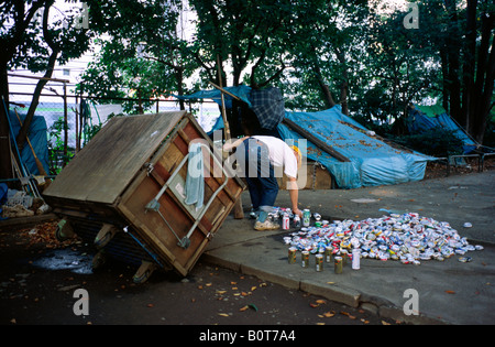 Nov 10, 2004 - uomo senza tetto in un piccolo parco in Tokyo ricicla lattine di bevande al fine di fare un po' di denaro dalla loro vendita. Foto Stock