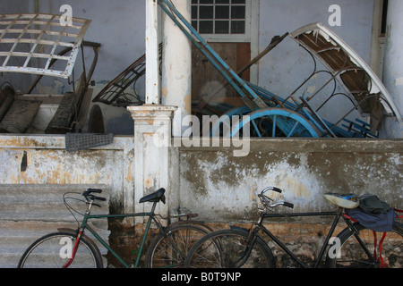 Vecchie biciclette e rickshaws memorizzati al di fuori di una casa a Galle, Sri Lanka Foto Stock