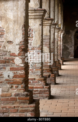 Pilastri in mattoni linea un passaggio pedonale vicino alla cappella presso la missione di San Juan Capistrano in California Foto Stock