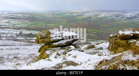 Neve pesante su Chinkwell Tor sul Parco Nazionale di Dartmoor guardando giù nel verde lussureggiante della valle Widecombe al di sotto di Foto Stock