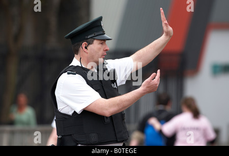 PSNI servizio di polizia dell'Irlanda del Nord officer facendo segnali a mano dirigere traffico Foto Stock