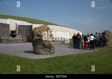 Tour con guida gruppo di turisti al di fuori del passaggio megalitico tomba e pietre permanente newgrange , nella contea di Meath Foto Stock