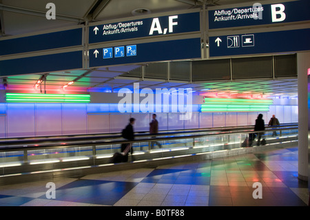 Passeggeri su tapis roulant nell' Aeroporto Internazionale di Monaco di Baviera Germania terminale Foto Stock