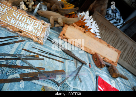 Intagliatori del legno strumenti ed esempi del suo lavoro. Sanur, Bali, Indonesia Foto Stock