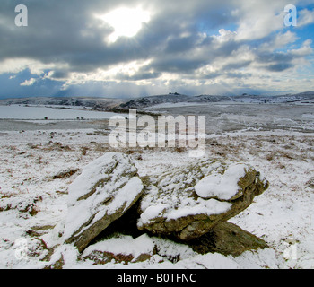 Neve pesante vicino Chinkwell Tor sul Parco Nazionale di Dartmoor con due massi di granito in primo piano e un cielo tempestoso Foto Stock