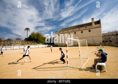 I bambini che giocano a calcio davanti a El Valle Chiesa, Siviglia, Spagna Foto Stock