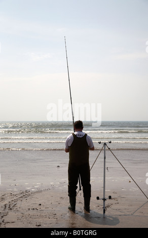 L'uomo seafishing trattura nella sua linea sul pollice strand beach County Kerry penisola di Dingle Repubblica di Irlanda Foto Stock