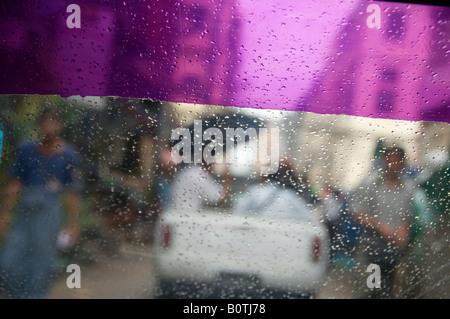 Scena di strada come visto attraverso la parte anteriore del parabrezza auto in un giorno di pioggia Myanmar Foto Stock