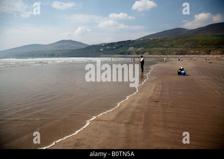 Acqua pulita onde venire a terra con uomo seafishing per la spigola su inch strand beach County Kerry penisola di Dingle Repubblica di ire Foto Stock