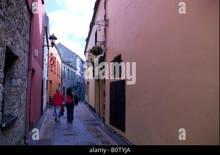 Due donne a piedi verso il basso un colorato street a Galway Foto Stock