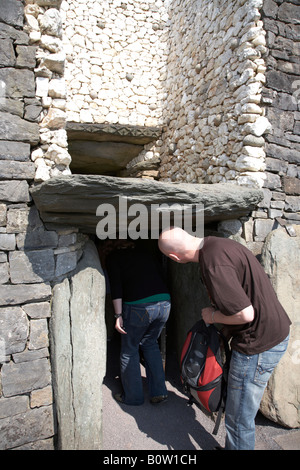 Gruppo di tour che entra nel passaggio tomba in newgrange mostra roofbox , nella contea di Meath , Repubblica di Irlanda Foto Stock