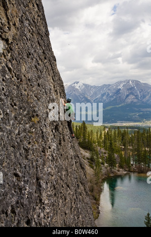 Giovane scalatore di alto sul lago nelle Montagne Rocciose Canadesi Foto Stock