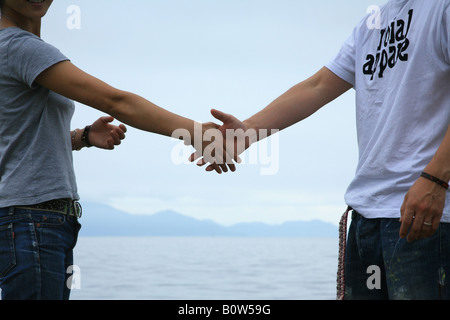 Giovane stringono le mani Foto Stock